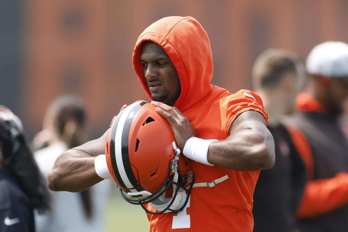 Browns quarterback Deshaun Watson holds his helmet as he takes a break during drills.