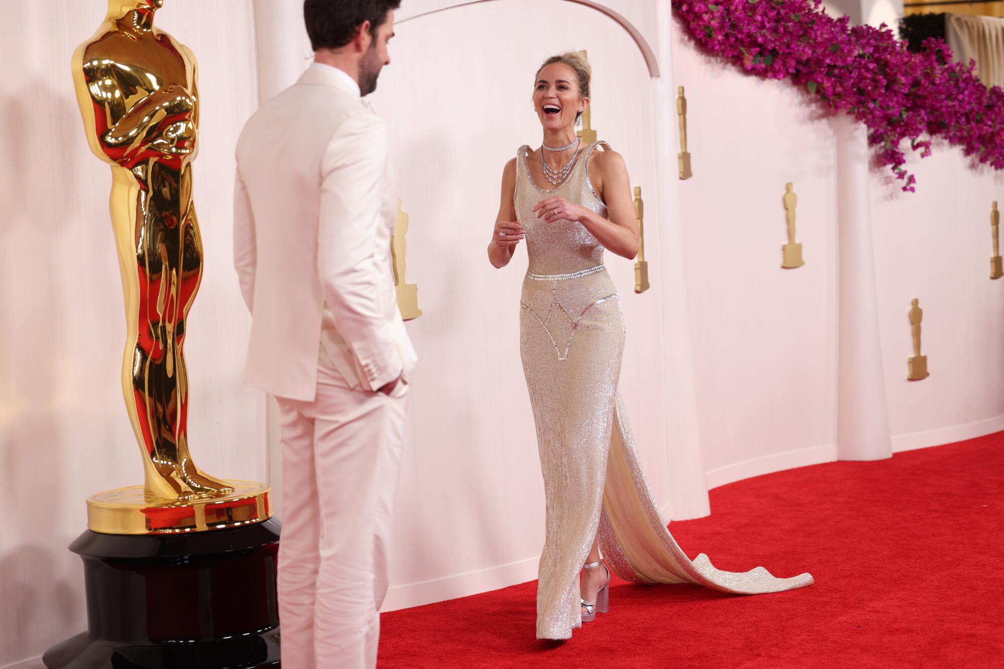 John Krasinski and Emily Blunt laugh on the red carpet. 