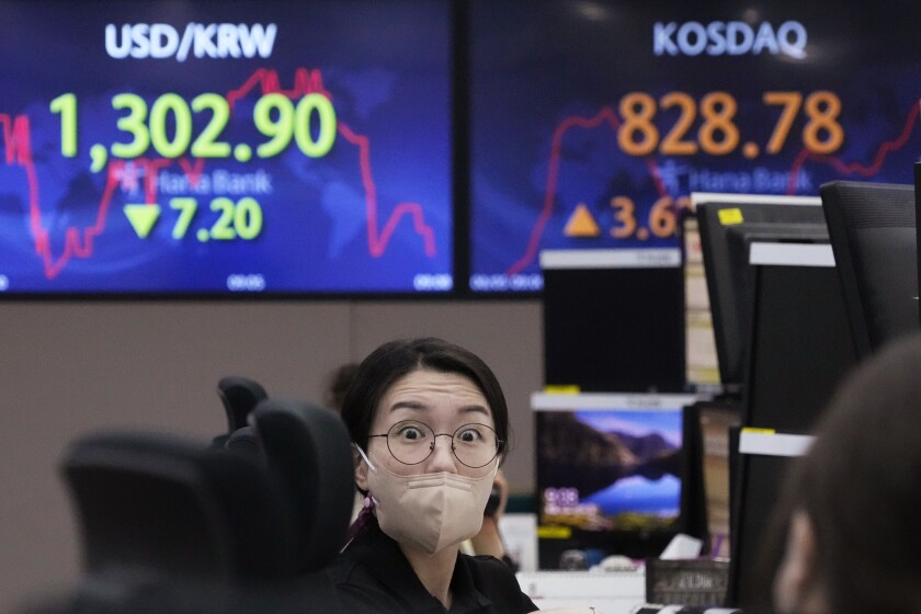 A currency trader talks with her colleague at the foreign exchange dealing room of the KEB Hana Bank headquarters in Seoul, South Korea, Friday, Aug. 5, 2022. Asian stock markets rose Friday ahead of U.S. job market data that might influence Federal Reserve decisions about further interest rate hikes. (AP Photo/Ahn Young-joon)
