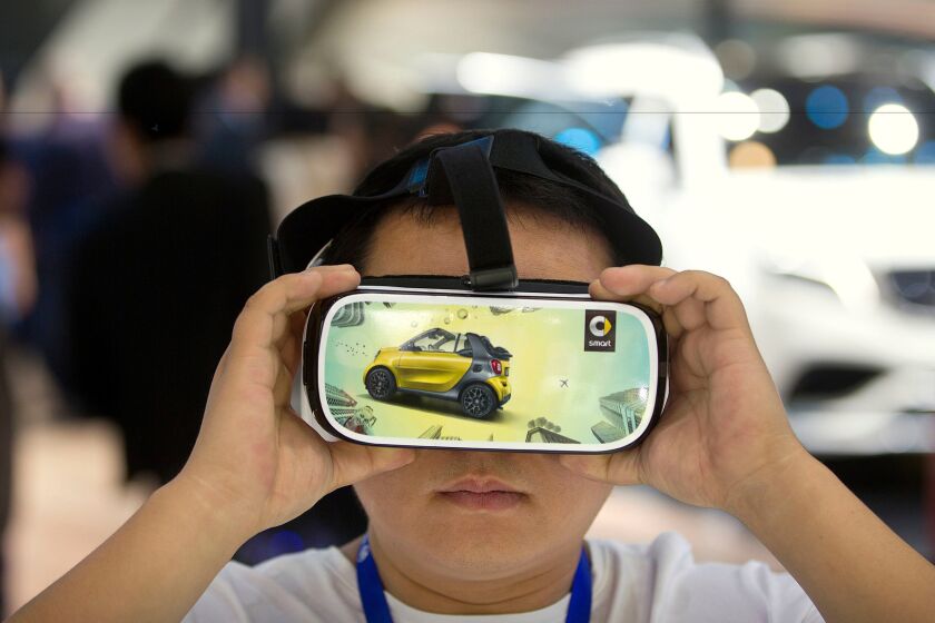 A visitor watches a virtual reality presentation in Beijing, April 26, 2016.