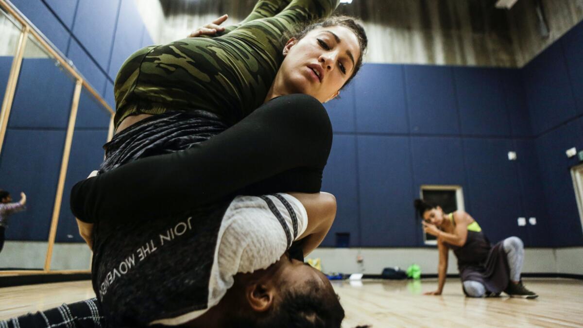 Bianca Medina holds Jasmine Stanley during a recent rehearsal at the Nate Holden Performing Arts Center.