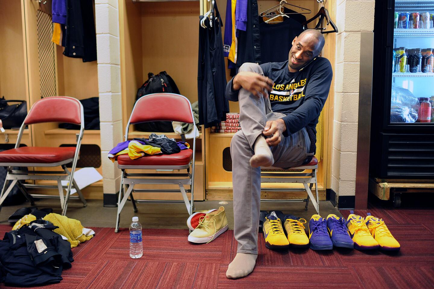 Kobe Bryant talks on the phone in the locker room before a game against the Rockets in Houston.