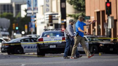Investigators examine the crime scene outside El Centro College in Dallas, where a sniper unleashed a barrage of bullets, killing at least five police officers and wounding seven others during a protest over recent police shootings in Minnesota and Louisiana.