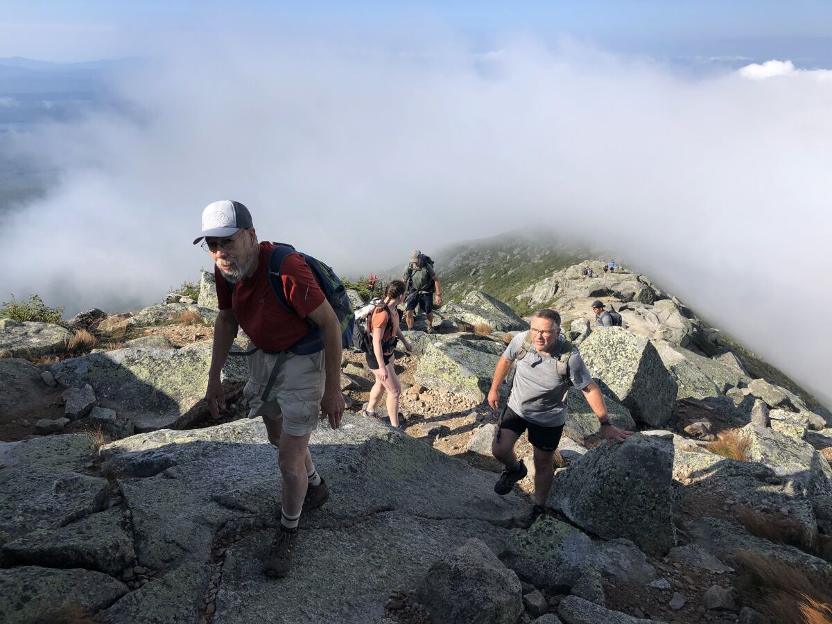 People hike up a rocky mountain