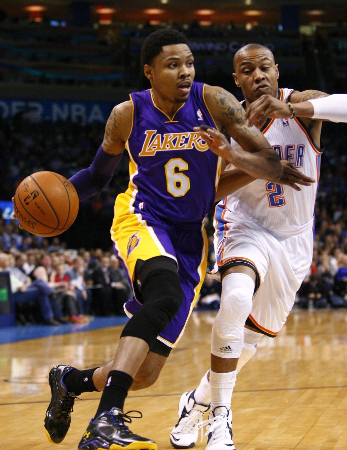 Kent Bazemore is defended by Oklahoma's Caron Butler during the first half of the Lakers' game against the Thunder at Chesapeake Energy Arena.
