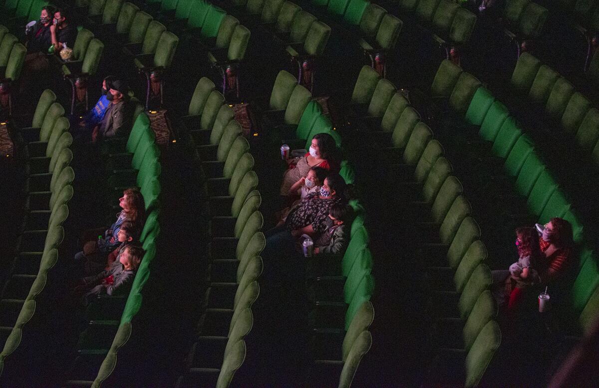 Moviegoers spread out by rows at a theater.