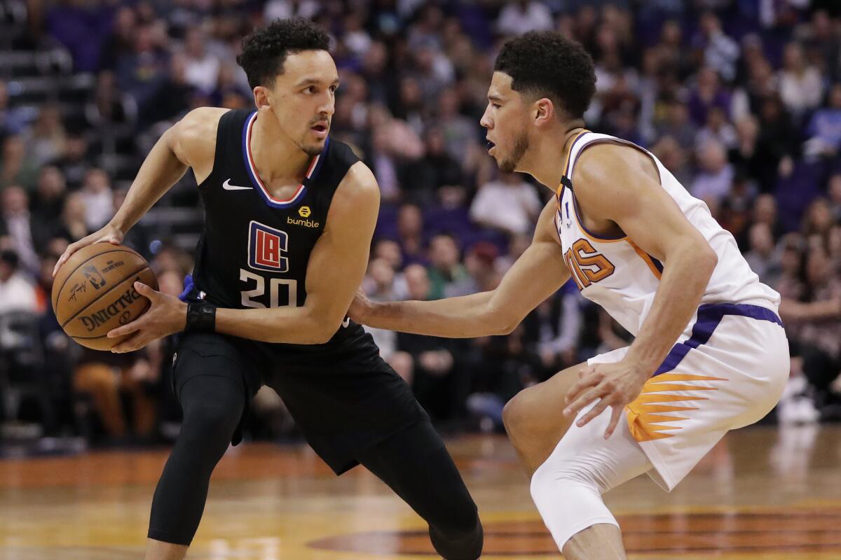Clippers guard Landry Shamet looks to pass as Phoenix Suns guard Devin Booker defends on Feb. 26 in Phoenix.