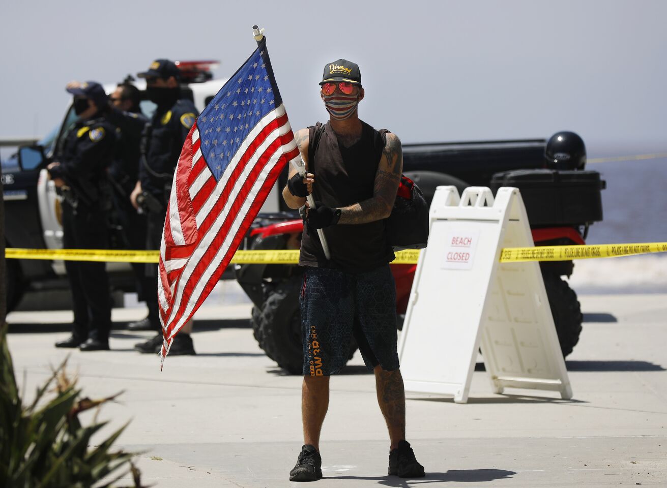 A protester stands on the boardwalk during A Day of Liberty rally in Pacific Beach on Sunday, April 26, 2020. The protesters were against the government shutdown due to the coronavirus.