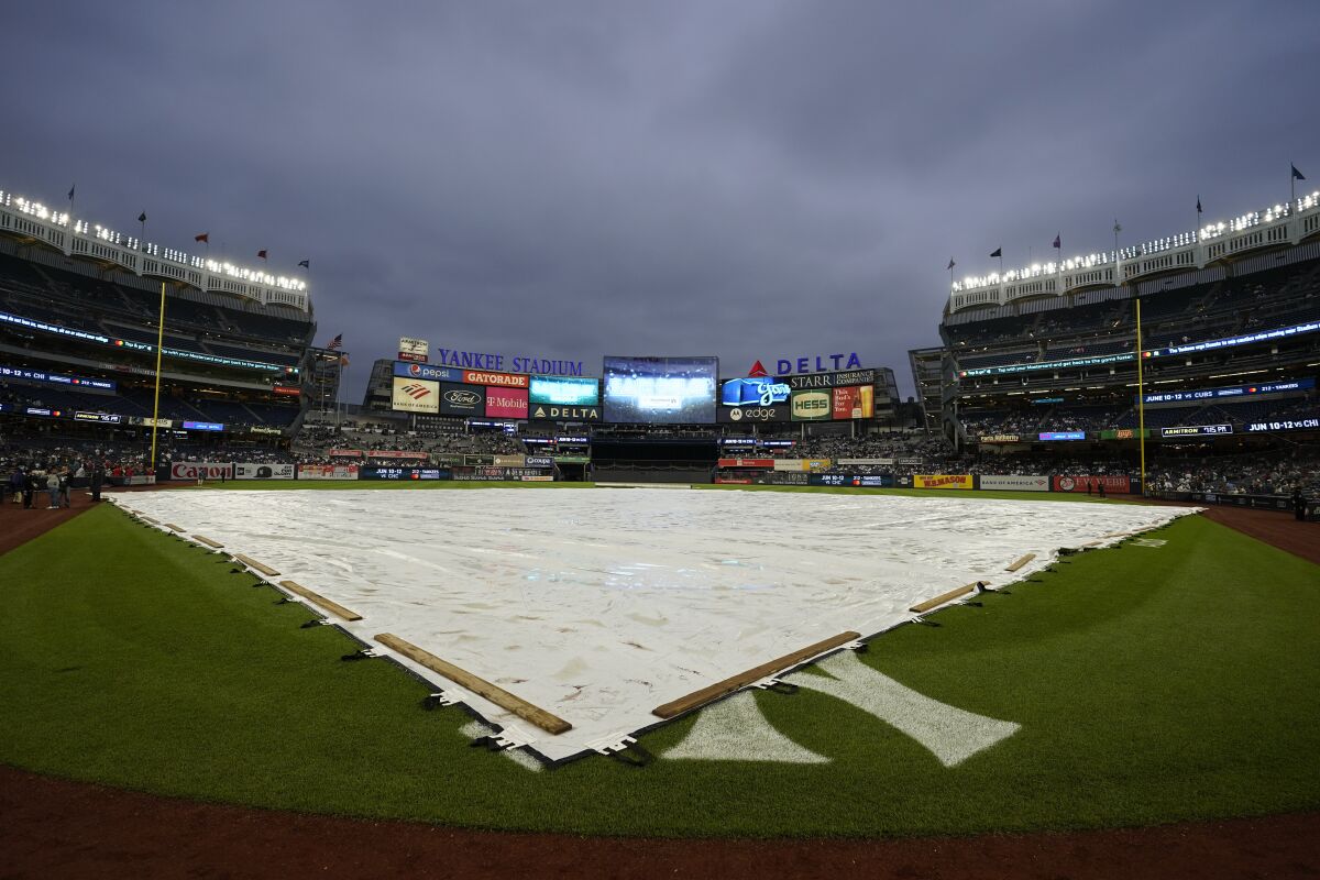 A tarp covers the field during a rain delay before a baseball game between the New York Yankees and the Los Angeles Angels, Wednesday, June 1, 2022, in New York. (AP Photo/Mary Altaffer)