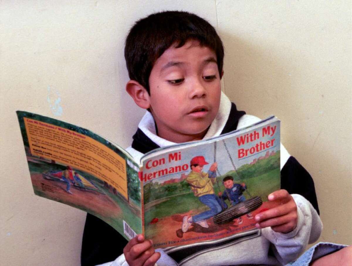 In this 1998 photo, Josh Lopez, 8, reads from a bilingual book in the third grade at Sheridan Way School in Ventura. A new study in the Annals of Neurology shows that learning a second language may help slow cognitive decline.