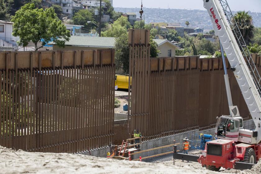 John Gibbins  U-T A construction crew Friday moves the last panel of fencing into place in the 14-mile, $147 million border wall replacement project just east of the San Ysidro Port of Entry. The new fencing replaces steel panels that were used during the Vietnam War.