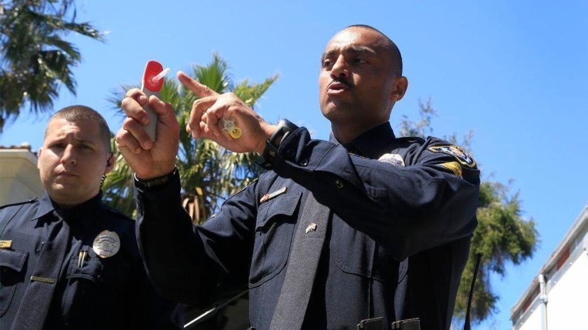 San Diego Police Officer Emilio Rodriguez demonstrates how a swab is placed into the Drager 5000, a portable drug analyzer. The portable analyzer detects the presence of a variety of drugs including marijuana. The devices will be used at sobriety checkpoints.