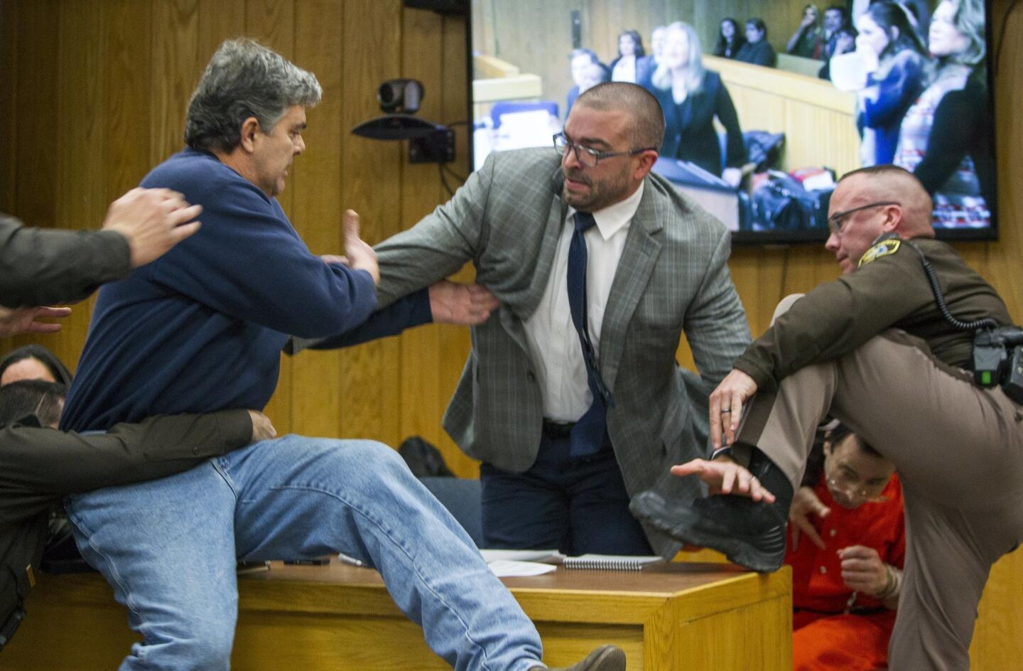 Randall Margraves, father of three victims of Larry Nassar, lunges at Nassar, bottom right, in Eaton County Circuit Court in Charlotte, Mich., on Feb. 2, 2018. The incident came during the third and final sentencing hearing for Nassar on sexual abuse charges.