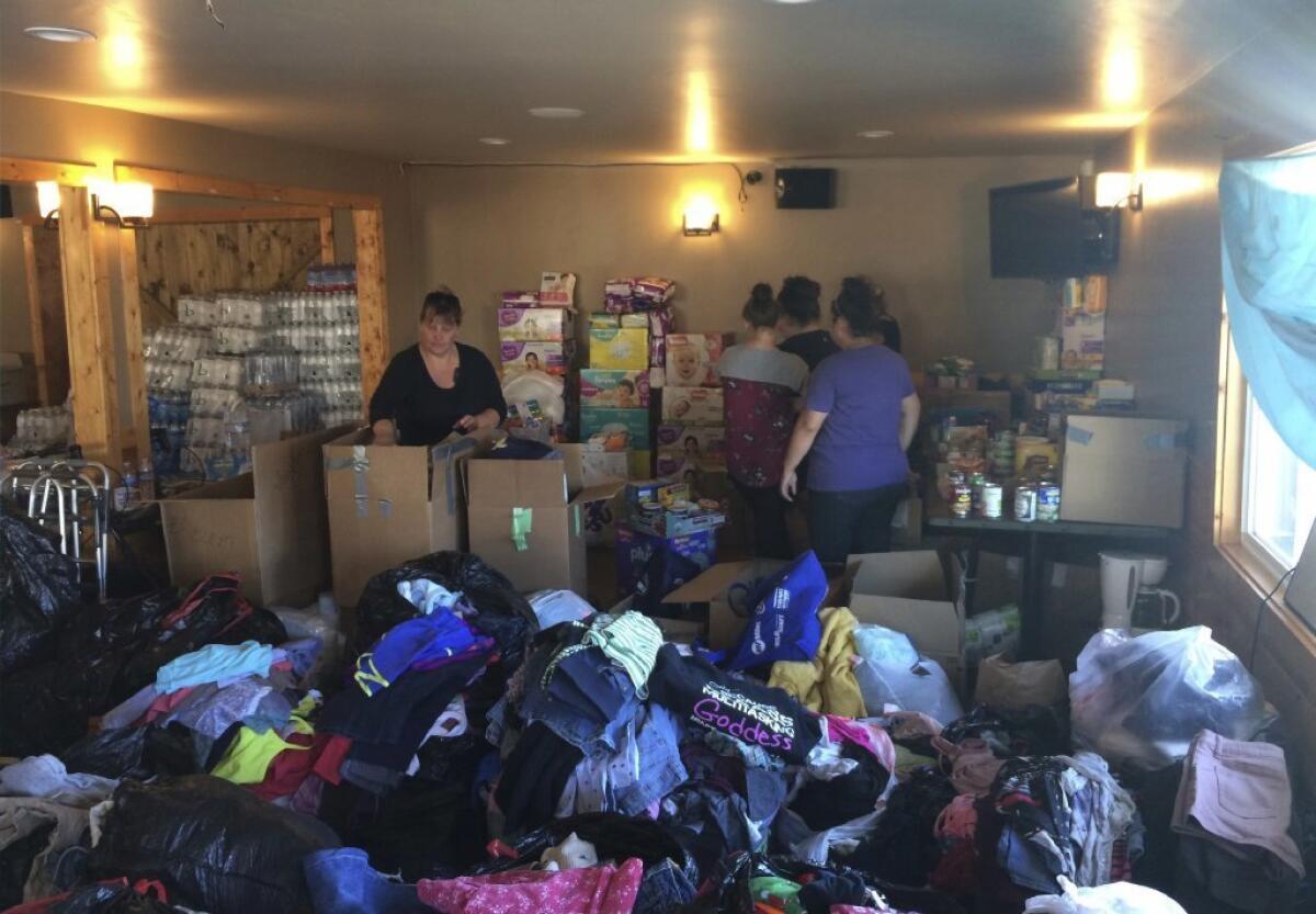 Redwood Valley residents sort through donations and supplies at McCarty's Bar, which turned into an evacuation center in Redwood Valley, Calif. on Saturday, Oct. 14.