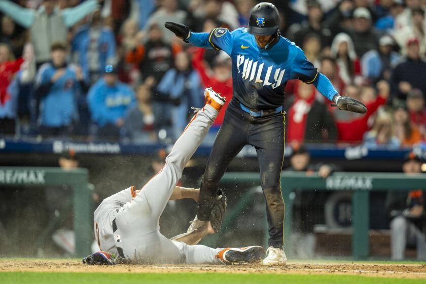 Philadelphia Phillies' Trea Turner, right, scores on the pass ball as San Francisco Giants starting pitcher Jordan Hicks, left, tries to make the tag during the fourth inning of a baseball game, Friday, May 3, 2024, in Philadelphia. (AP Photo/Chris Szagola)