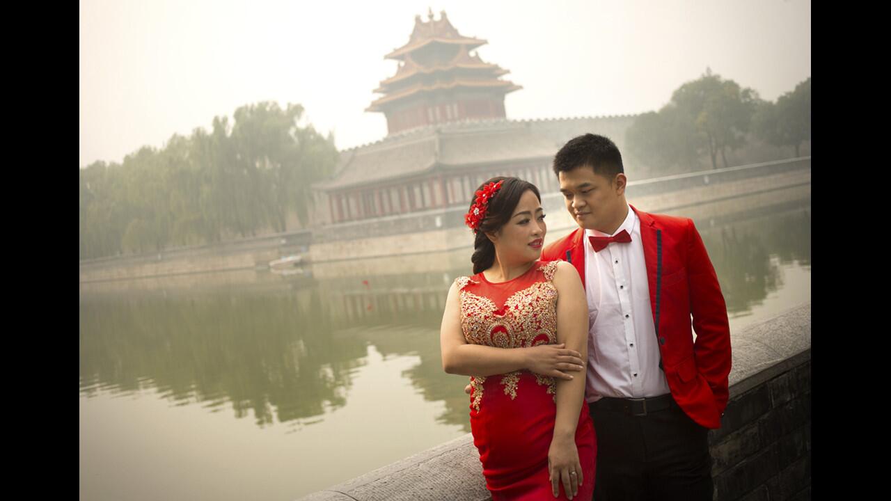 A couple poses for a portrait outside the Forbidden City on a polluted day in Beijing on Oct. 7.