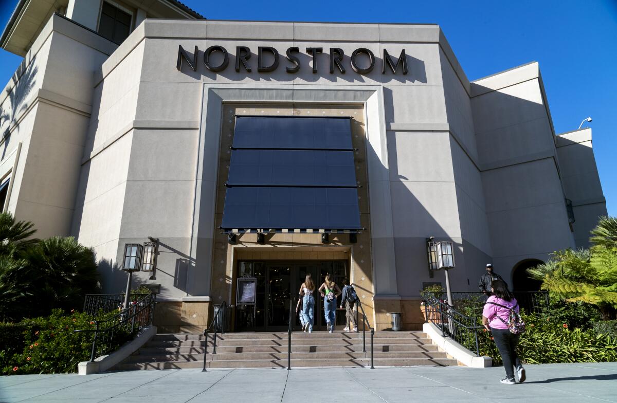 Security patrols Nordstrom as shoppers enter.