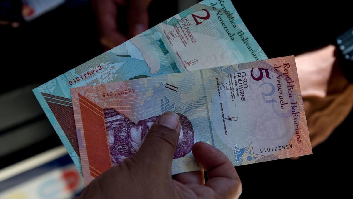 A man shows new 5-bolivar notes in Caracas on Monday.