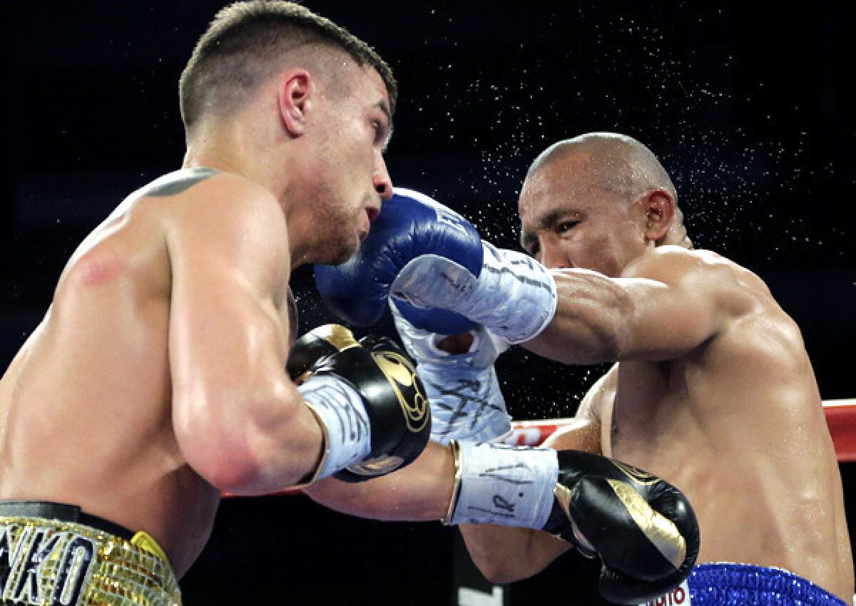 Orlando Salido, right, and Vasyl Lomachenko trade punches during their 12-round featherweight title bout on in March 2014. Salido won by split decision.