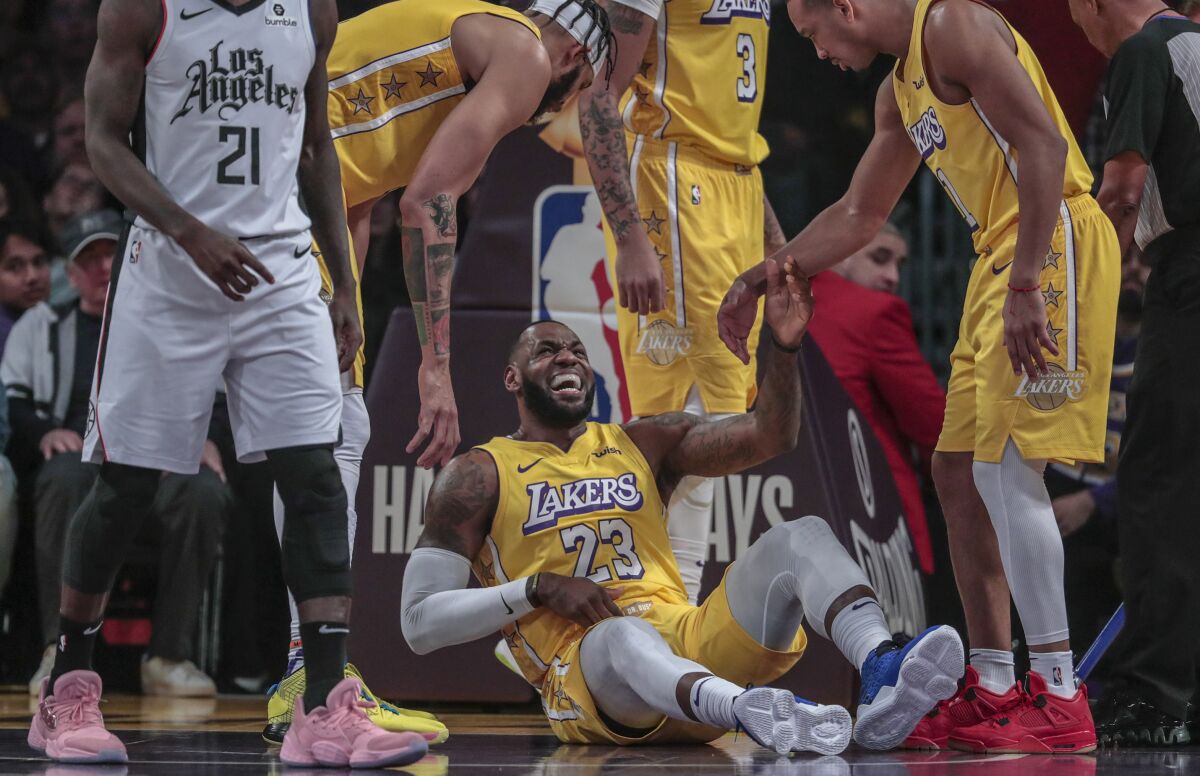 Lakers forward LeBron James grimaces in pain after colliding with Clippers guard Patrick Beverley on Dec. 25, 2019, at Staples Center.
