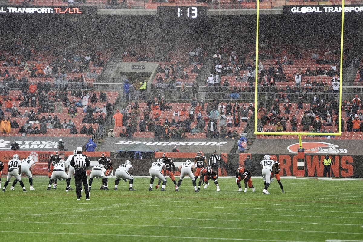 FILE - In this Sunday, Nov. 1, 2020, file photo, the Cleveland Browns and the Las Vegas Raiders line up as snow falls during an NFL football game in Cleveland. Browns center JC Tretter, president of the players' union, has called for all NFL stadiums to put in natural grass fields; this season, 17 stadiums have it, while 13 have synthetic surfaces. (AP Photo/David Richard, File)