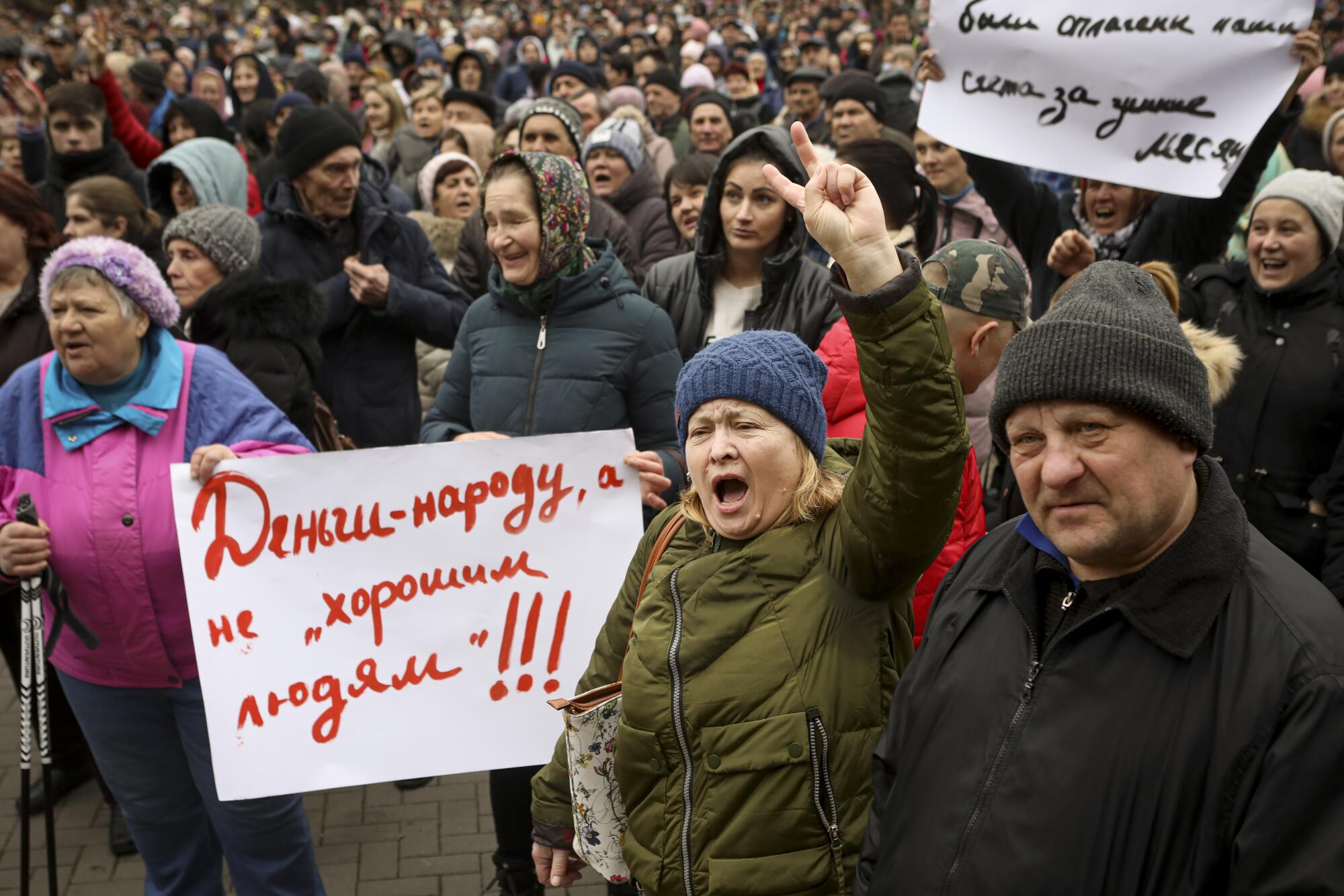 A large crowd of people holding protest signs outdoors.