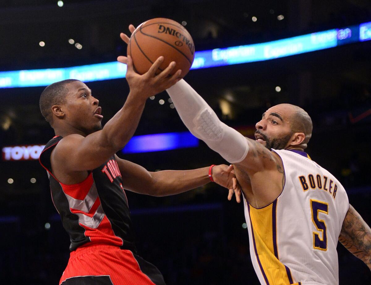 Lakers forward Carlos Boozer tries to block a shot by Raptors All-Star point guard Kyle Lowry during a eariler in the season. Boozer said he would return Wednesday against New Orleans after a five-game layoff to evaluate younger post men.