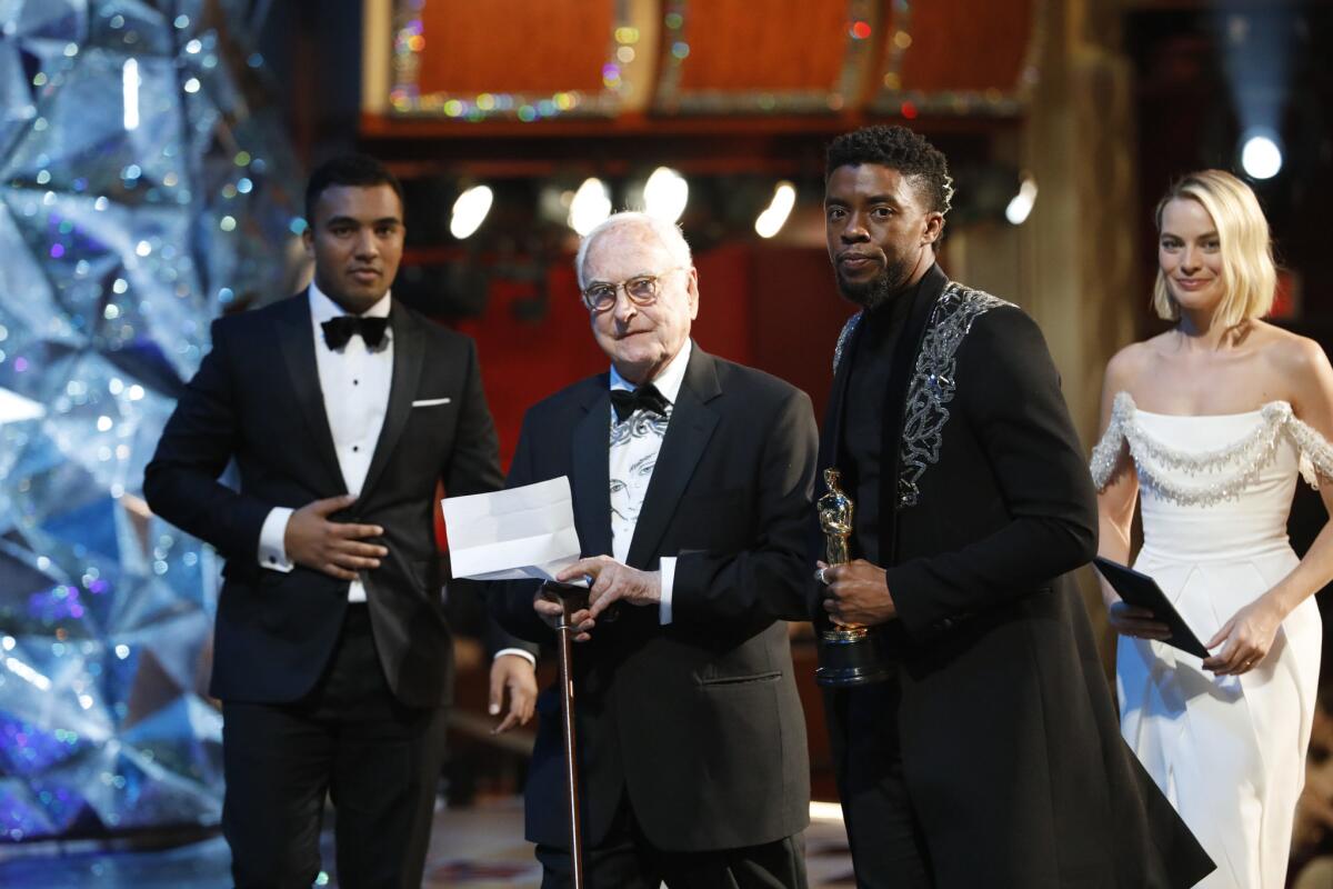 James Ivory, center, after winning his adapted screenplay Oscar, with presenters Chadwick Boseman and Margot Robbie to his right at the 90th Academy Awards.
