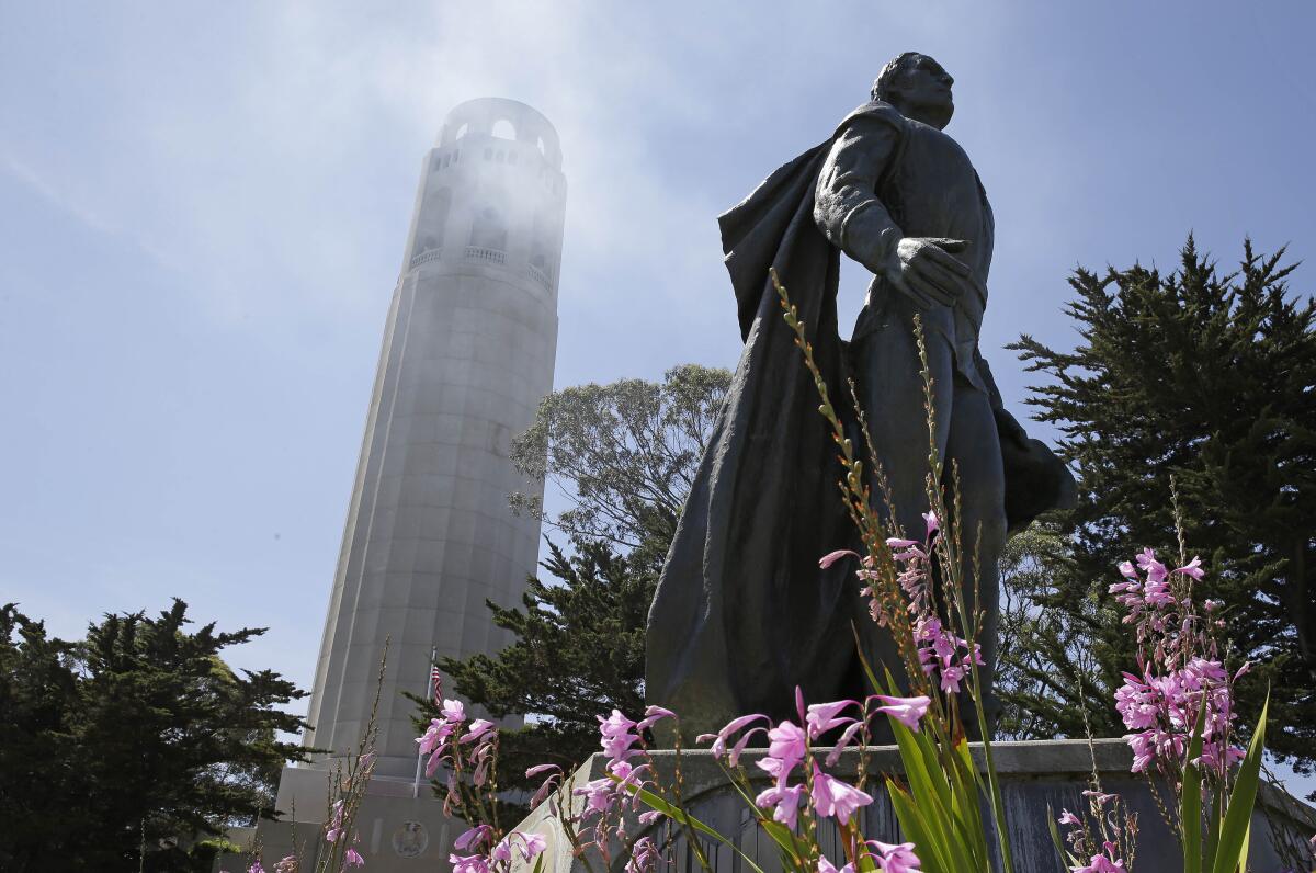 In San Francisco, a statue of Christopher Columbus stands beneath Coit Tower.