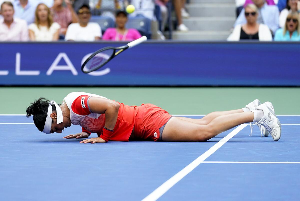 Ons Jabeur, of Tunisia, falls to the court after missing a shot from Iga Swiatek, of Poland, during the women's singles final of the U.S. Open tennis championships, Saturday, Sept. 10, 2022, in New York. (AP Photo/Matt Rourke)