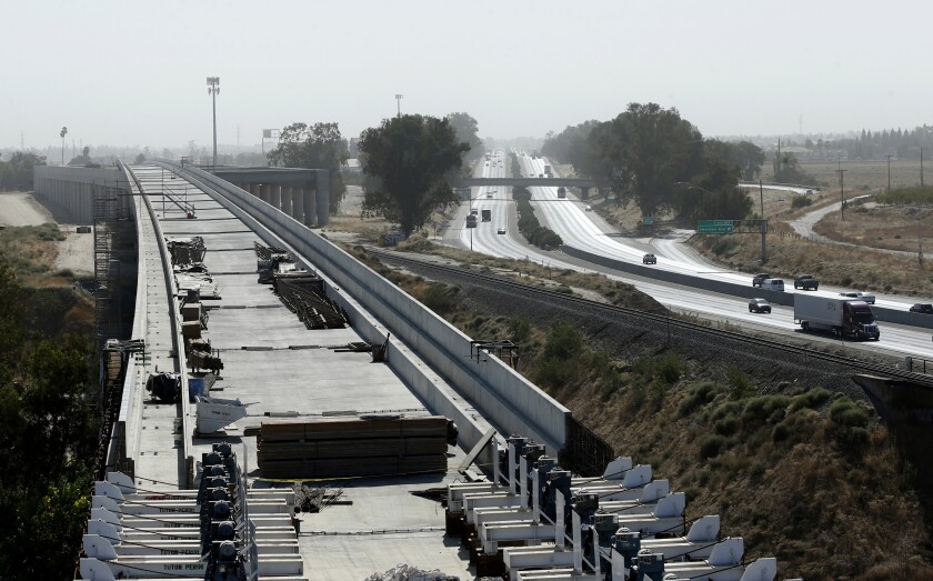 FILE - This Oct. 9, 2019, file photo shows the high speed rail viaduct paralleling Highway 99 near Fresno, Calif. Brian Kelly, the chief executive officer of The California High-Speed Rail Authority, said in a letter released Friday, Feb. 5, 2021, that a 119-mile segment of track in the Central Valley now won't be completed until 2023, a one-year delay. (AP Photo/Rich Pedroncelli, File)
