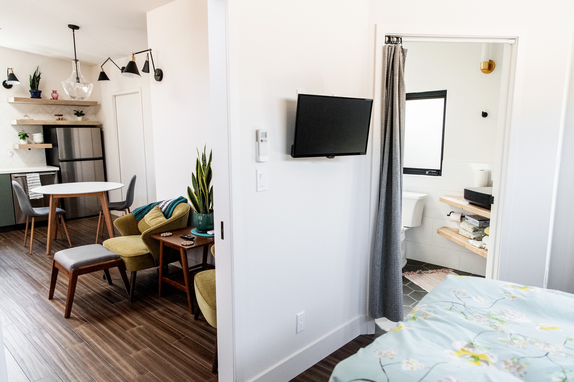 A living room and part of a bedroom is seen from the bedroom's vantage point.