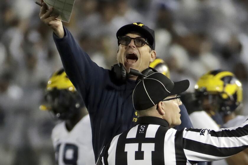 Michigan coach Jim Harbaugh, center, argues a call during the first half of the team's NCAA college football game against Penn State in State College, Pa., Saturday, Oct. 19, 2019. (AP Photo/Gene J. Puskar)