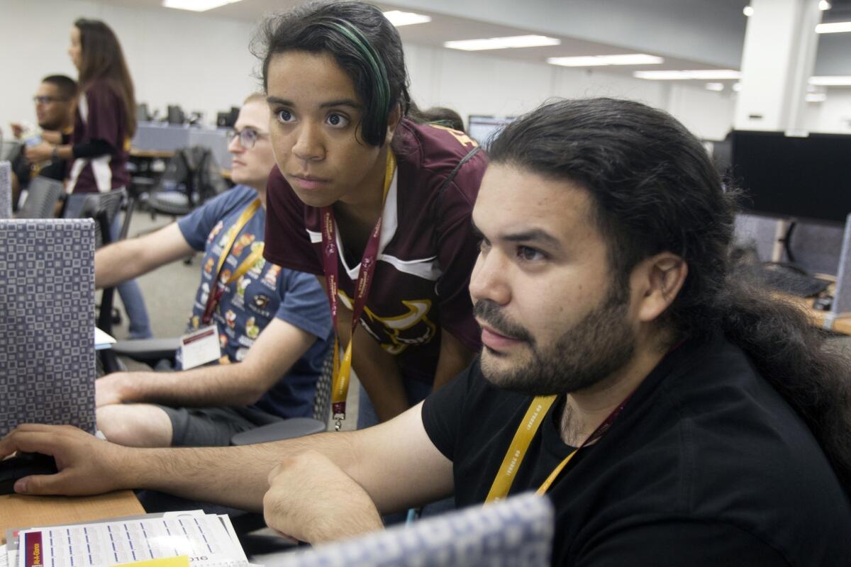 Kiomanie Machon, center, helps Rudy Leyva register for classes during student orientation at Cal State Dominguez Hills. Cal State recently launched a program to help professors find low-cost options for student course materials.