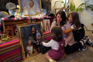 San Diego, CA - November 17: At the family’s home in Serra Mesa on Thursday, Nov. 17, 2022 in San Diego, CA., Joanna Hurtado, 32 and her daughters, Emalee Herrera, 8 and Penelope Herrera, 1, sat near the ofrenda they have setup to memorialize her fiancé and father of her children, Albert Herrera, 32. (Nelvin C. Cepeda / The San Diego Union-Tribune)