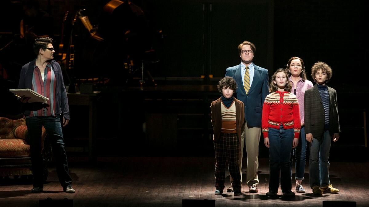 Alison Bechdel (played by Kate Schindle, left) looks toward her childhood self (Alessandra Baldacchino, in the red sweater) surrounded by her family in "Fun Home."