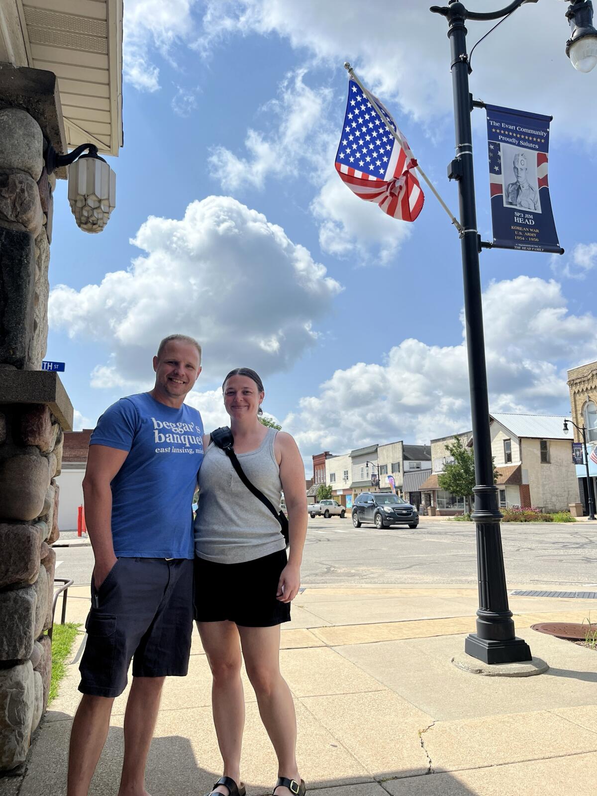 Justin Patterson and Brandy Jones side-hug on a street corner in downtown Evart, Mich.