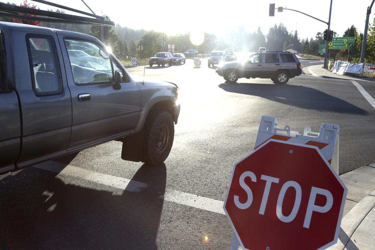 Drivers navigate through an intersection with signals out and stop signs put in place during the power shutdown in Grass Valley.