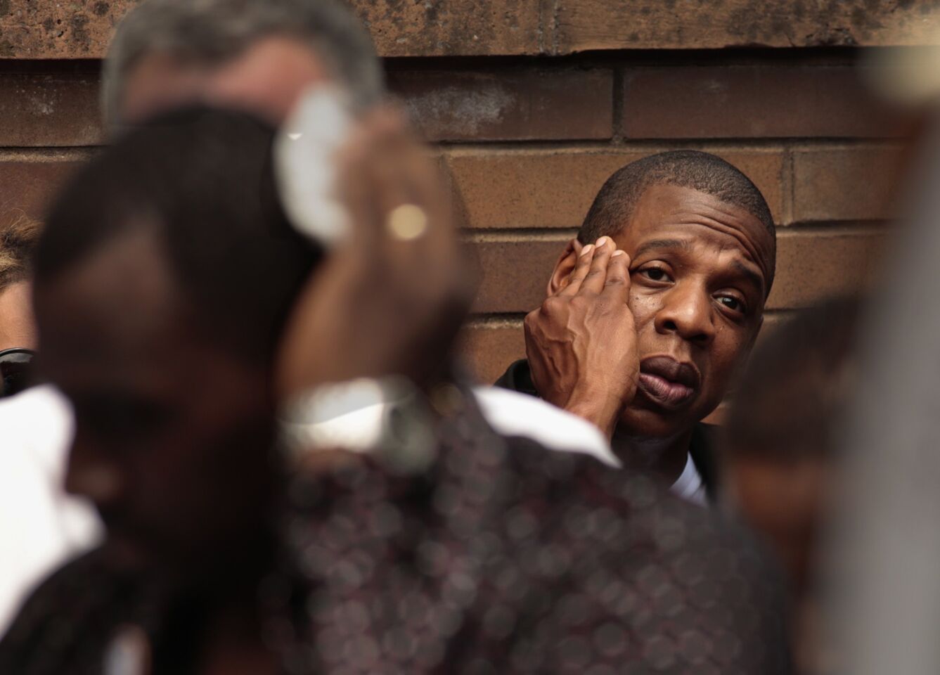 Jay Z wipes sweat from his face during a rally at Manhattan police headquarters. He, along with Beyonce, was there to show his support for the family of Trayvon Martin.