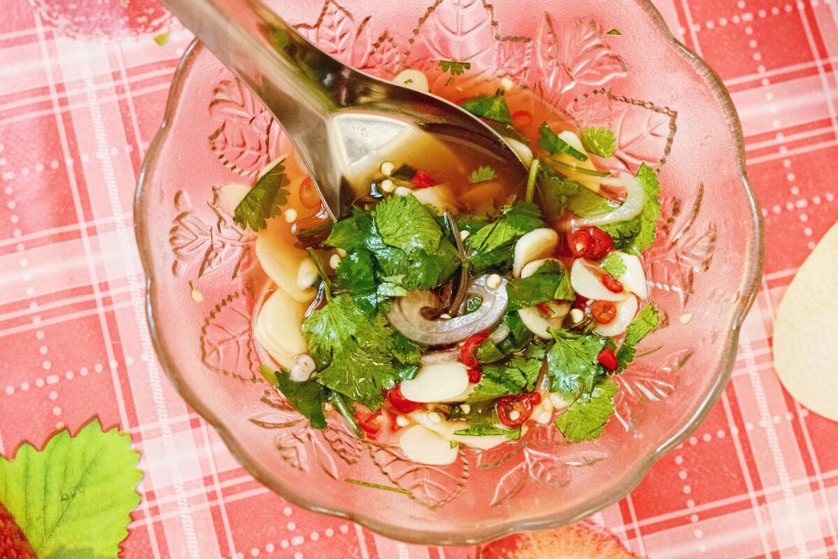 An overhead of a small glass bowl of Holy Basil's classic Prik Nam Pla