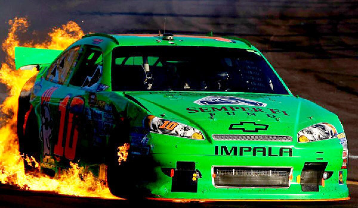 Danica Patrick drives the wrecked No. 10 GoDaddy.com Chevrolet as flames shoot from the back of her car after an incident in the NASCAR Sprint Cup Series AdvoCare 500 at Phoenix International Raceway on Nov. 11, 2012.