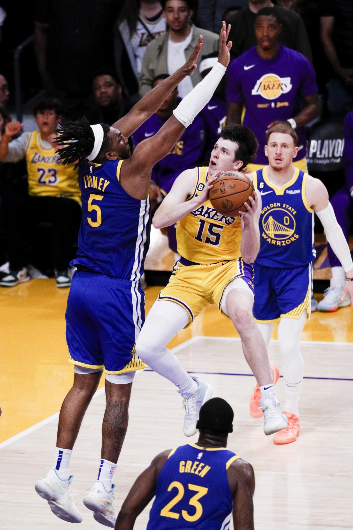 Lakers guard Austin Reaves, right, elevates for a layup against Warriors forward Kevon Looney.