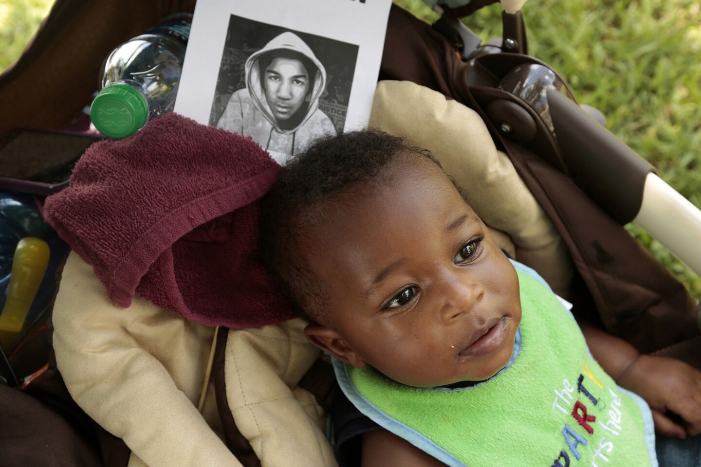 Eight-month-old Khaleel James rests in the shade next to his mother, Christina King, of Orlando, Fla., as a crowd awaits a verdict.