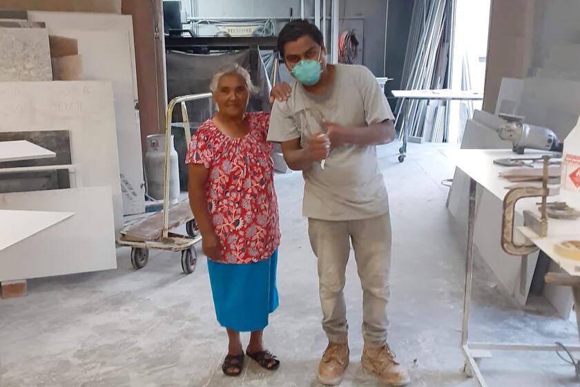 Gustavo Reyes Gonzalez cut artificial stone at Orange County workshops like this one, where he is pictured with his mother.