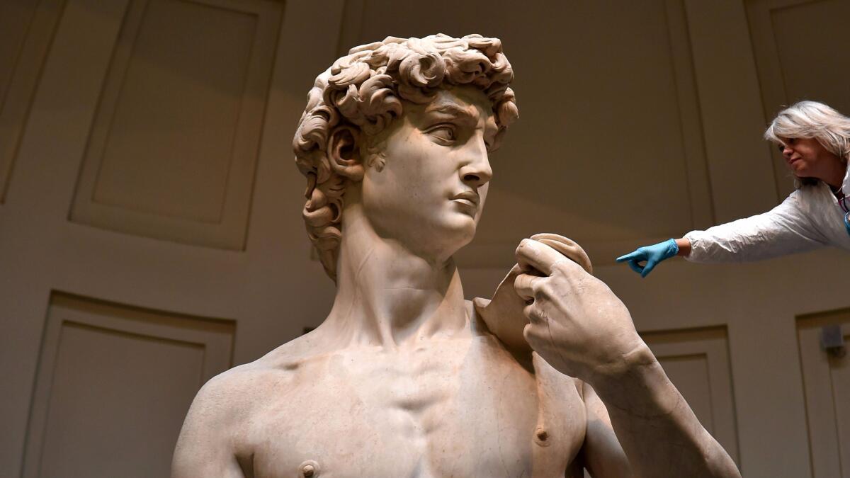 An Italian restorer from the Friends of Florence Assn. cleans Michelangelo's David at the Galleria dell'Accademia in Florence.