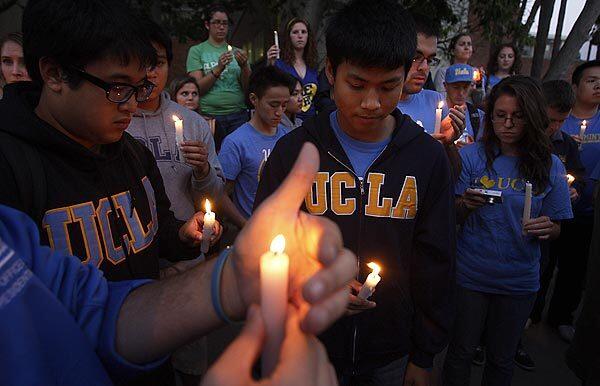UCLA students gather Friday outside the UCLA Ronald Reagan Medical Center after hearing that legendary Bruins basketball coach John Wooden had passed away. Wooden, 99, won 10 national titles between 1964 and 1975. He had been in failing health for several months.