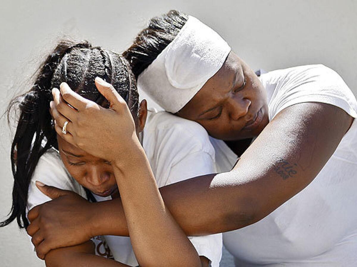 Tyisha Player, left, is comforted by her friend, Talonnie Smith, as family members gather near the spot in Athens where her husband, Woodrow Player Jr., was shot and killed by sheriff's deputies.
