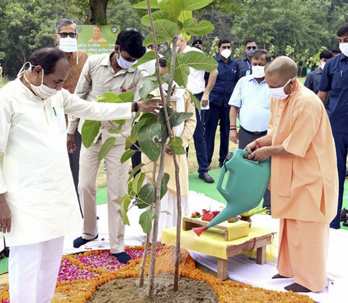 In this photo released by India's Uttar Pradesh state government, Uttar Pradesh Chief Minister, Yogi Adityanath, right, inaugurates a day long tree planting campaign across the state in Lucknow, India, Sunday, July 5, 2020. (Uttar Pradesh state government via AP)
