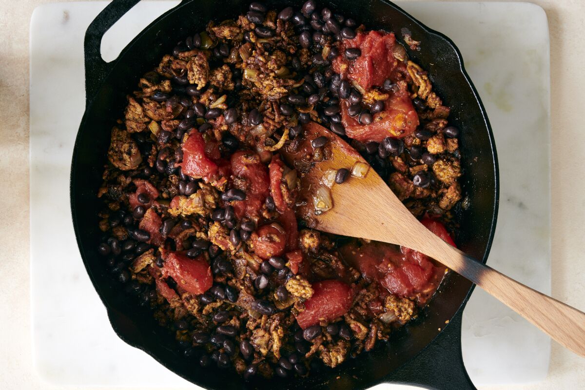 Turkey chili cooks in a cast-iron skillet.