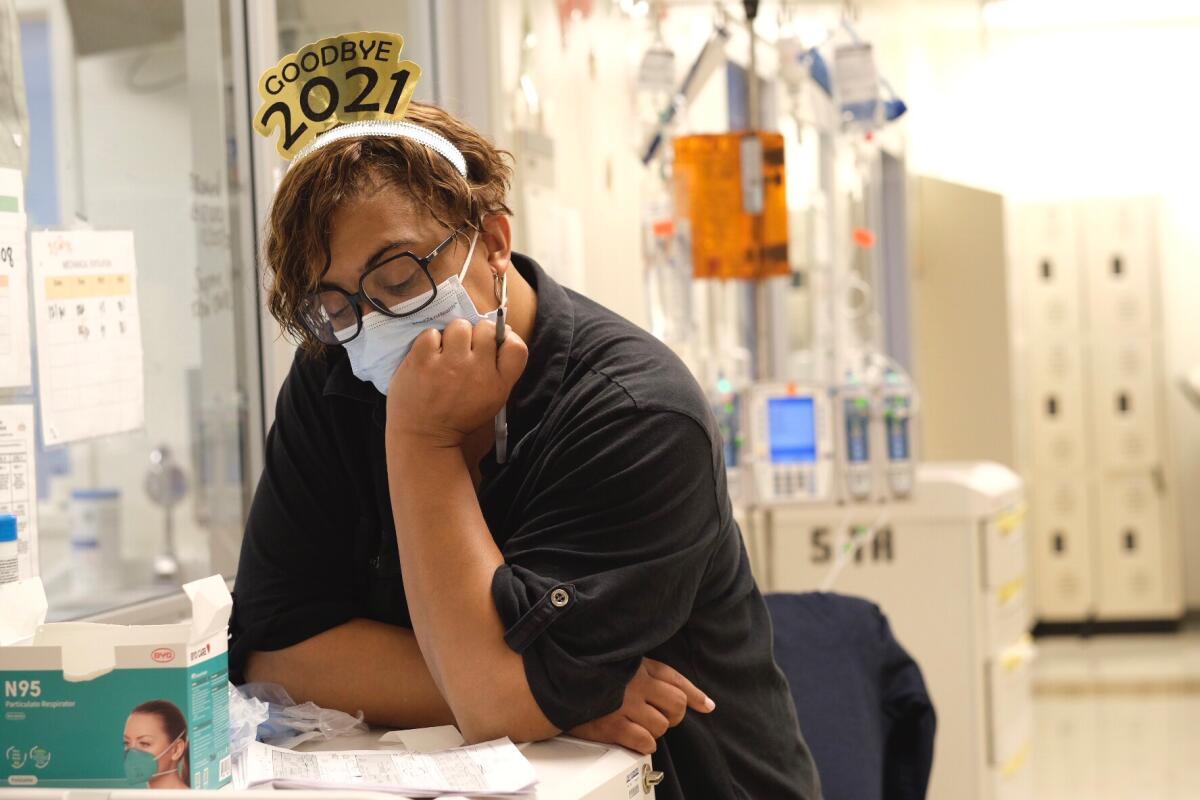 A nurse wears a headband reading "Goodbye 2021"